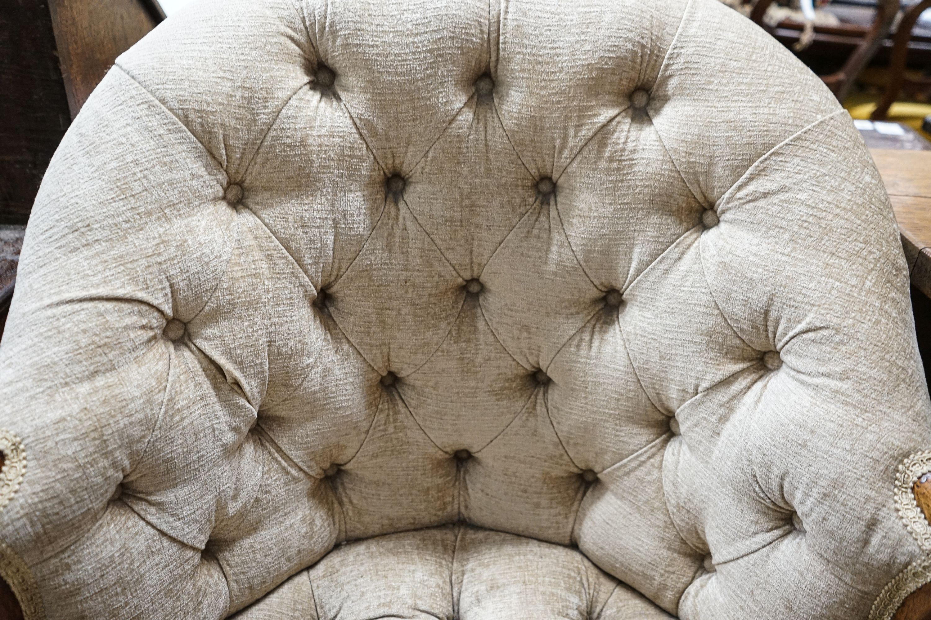 A George III Hepplewhite style mahogany tub chair, with later buttoned upholstery, acanthus carved arms and chamfered moulded squared legs, fitted brass castors, width 64cm, depth 50cm, height 97cm